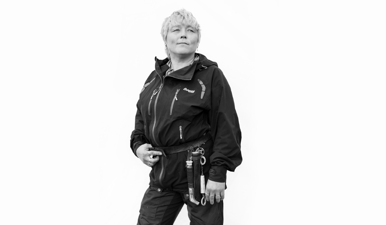Dame som står i sterk stilling og ser ut i det fjerne. Foto.